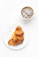 Croissant and cup of coffee, top view