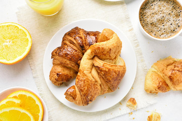 Fresh hot croissants, fruits and cup of coffee