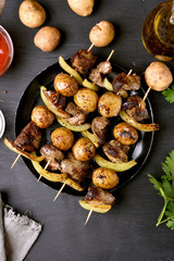 Chicken liver and vegetables skewers on black background