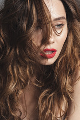 Fototapeta premium Fashion portrait of a lovely shirtless curly brown hair woman