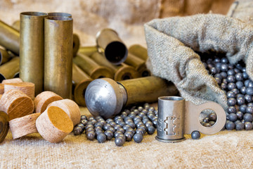 background on the old burlap lie brass metal shell casings with a shot