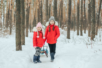 Fototapeta na wymiar two small children with sleds in the forest