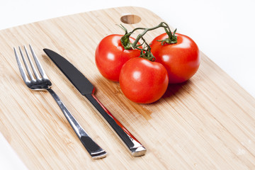 Red fresh tomatoes on chopping board