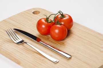 Red fresh tomatoes on chopping board