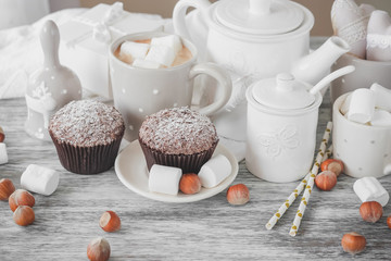 Cups with cacao and marshmallow, cupcakes and different decorations