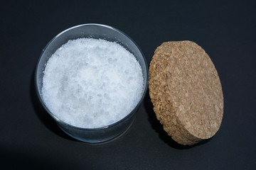 Sea salt in a glass with cork lid, black background