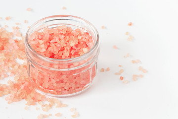 Fototapeta na wymiar Big Crystals of pink Himalayan salt in jar. White background. Top view. Isolated.