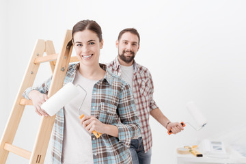 Happy couple painting their new home - obrazy, fototapety, plakaty