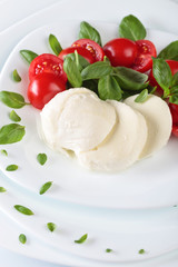 Mozzarella with tomato and green basil.