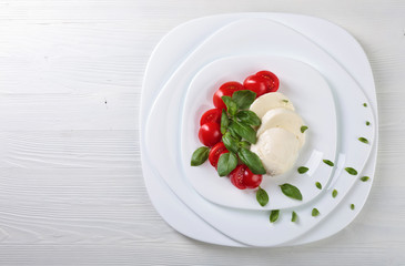 Mozzarella with tomato and green basil.