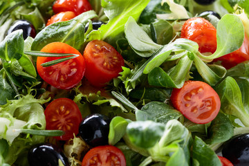 Green salad with tomatoes and black olives.