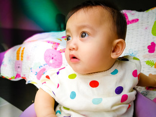 Candid portrait of a cute and expressive Asian baby girl. Lifestyle and childhood concept.