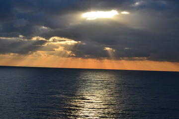 sonnenuntergang über dem Meer, Sonnenstrahlen zwischen den Wolken