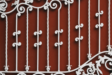 Fototapeta na wymiar red iron gate with white forged pattern