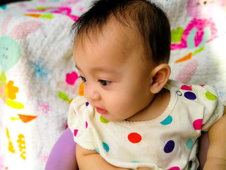 Candid portrait of a cute and expressive Asian baby girl. Lifestyle and childhood concept.