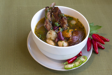 Soup with white and red beans, other vegetables and smoked pork ribs. With Chilies accent.