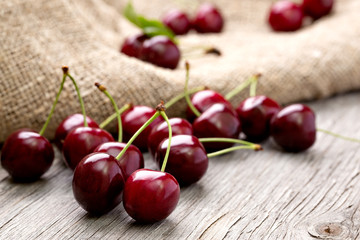 Ripe cherries are scattered on a wooden table