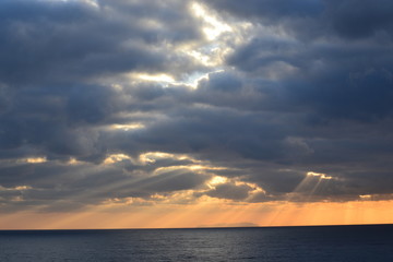 sonnenuntergang über dem Meer, Sonnenstrahlen zwischen den Wolken