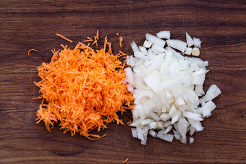 Finely chopped vegetable onions and carrots on a wooden board