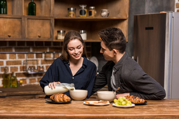 girlfriend pouring milk in plate at kitchen