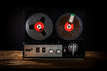 Tape recorder on wooden table with black background