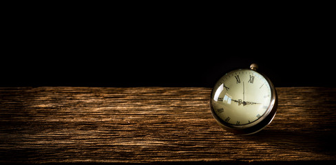 Vintage crystal clock on wooden table with black background