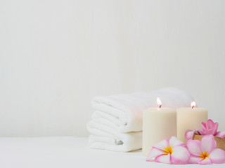 spa wellness set.beauty and fashion set on the white table.spa towel with candle and plumeria, tree...
