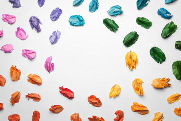Colorful background made of dried flower leaves with copy space in middle.