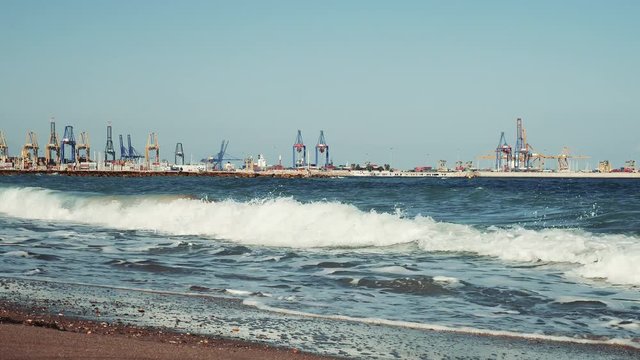 Gr&uacute;as del puerto de Valencia y olas en la playa de Pinedo