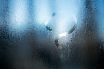 question mark on wet misted glass.close up, selective focus, blurred background