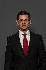 Portrait of successful confident businessman looking at the camera against gray background