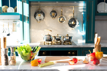 fresh vegetables and spices on table in empty kitchen