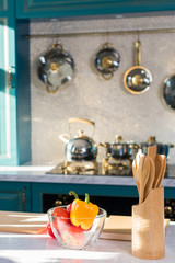 wooden utensils and fresh vegetables in bowl on kitchen table