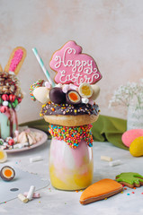 Easter freak shake decorated with Easter bunny gingerbread on table