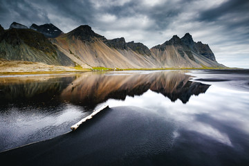 Beach with wet black sand. Location Stokksnes cape, Iceland.