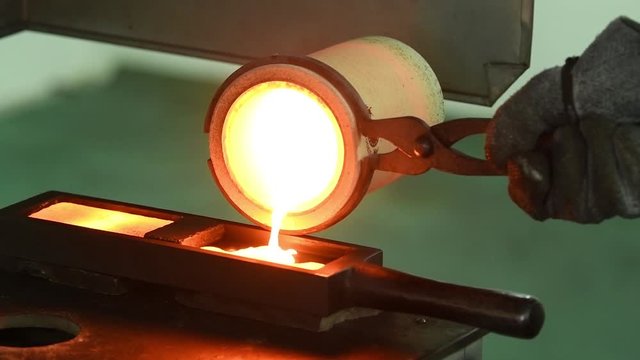 Melting gold. Molted metal pouring into bar form