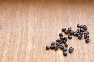 Fototapeta na wymiar Roasted coffee beans scattered on red-grey wooden background