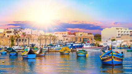 Beautiful panorama of Valletta harbor in Malta, with boats and architecture illuminated by sunset light - obrazy, fototapety, plakaty
