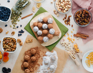 Vegan candies from dried fruits and nuts covered with cocoa powder and coconut chips