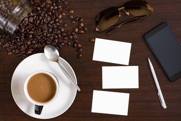 Cup of coffee from above, lay flat image, with coffee beans on wood table.