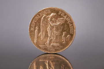 a gold antique coin of 100 francs in 1879 with the image of an angel, the genius of the...