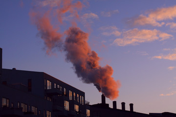 Heavy cloud of smoke from industrial chimney in sunset with copy space