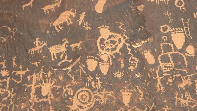 tilt down shot of ancient american indian drawings on newspaper rock at canyonlands national park in utah, usa