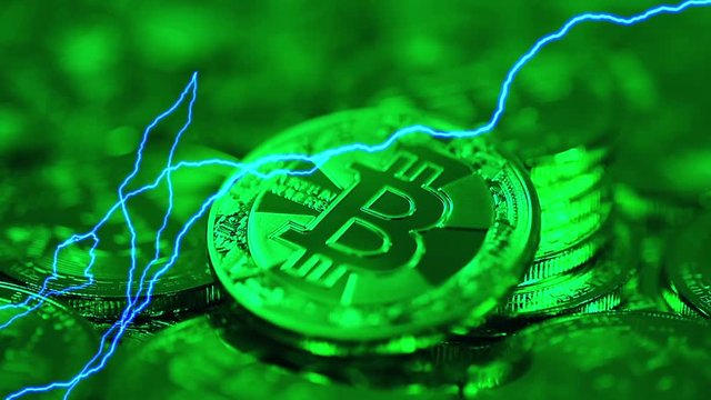 Blockchain technology, Bitcoins mining concept in green light with lightning, macro shot of bitcoins. Cryptocurrency Bitcoin, BTC, coins rotates in green light, power consumption concept