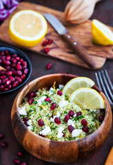 Delicious healthy cous cous salad with herbs, lemon zest, feta cheese and pomegranate seeds