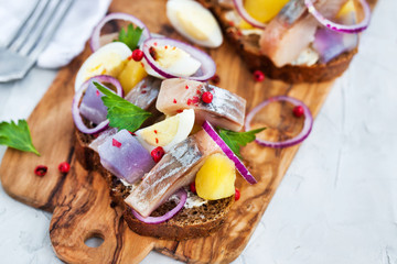 Open sandwich (smorrebrod) with herring, onion, potato and eggs
