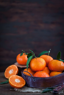 Fresh tangerines with leaves on  wooden table