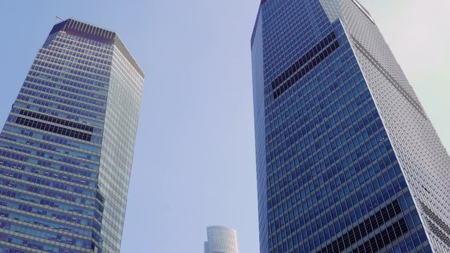 two skyscrapers between which the third one is visible against the blue sky in the Pudong area, Shanghai, China