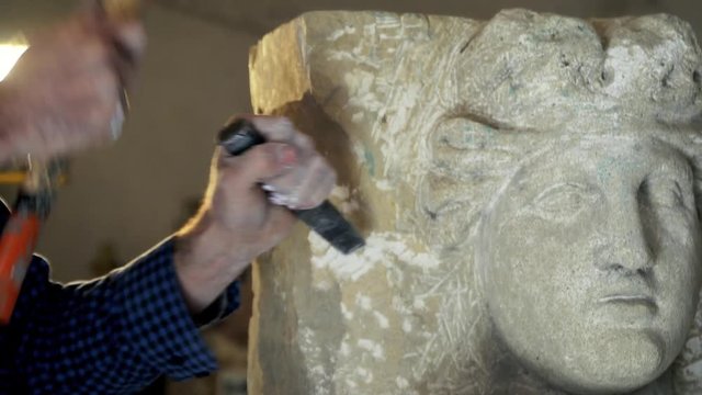 The artist creating sculpture of stone. Art studio. 