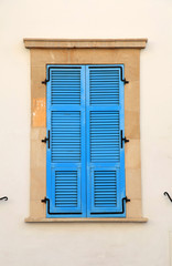 Vintage blue close window with shutters in old stone house
